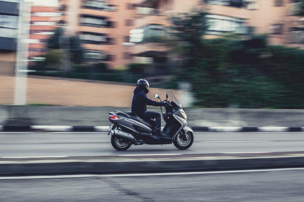 panning shot of a man on a scooter
